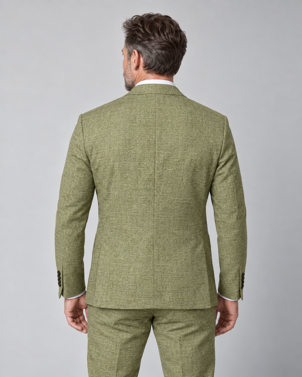Achteraanzicht van een man in een licht olijfgroen gemêleerd pak met colbert en pantalon